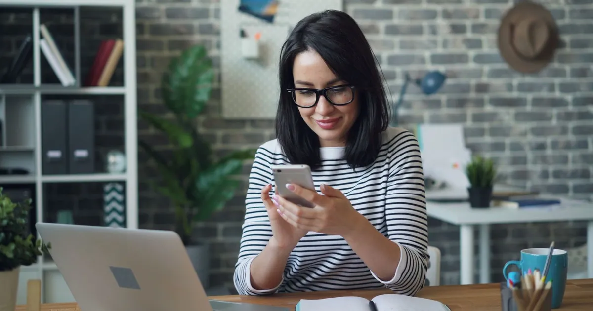 Professionnelle lisant un rappel SMS de rendez-vous sur son téléphone